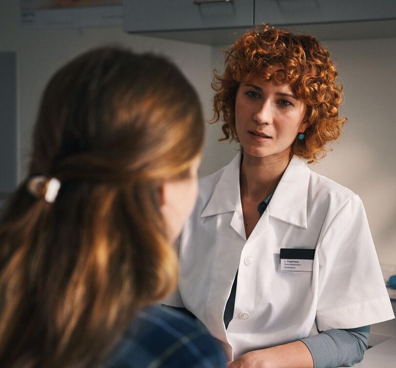 Pharmacist advises a customer in a conversation